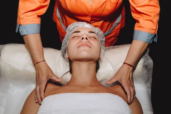 Lázeňský specialista dělá masáž ramen mladé dívce na lékařské čepici. postupy při zavírání těla — Stock fotografie