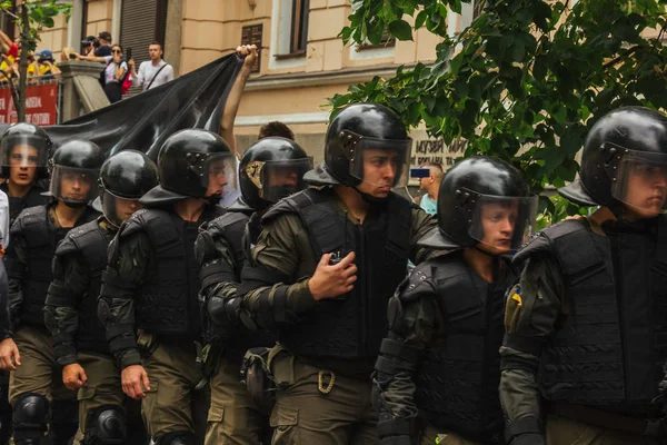 Kiev, Ucrania, 06.23.2019. La policía con cascos protectores y chalecos antibalas mantiene el orden en la reunión. fuerzas de seguridad en una marcha van en una columna — Foto de Stock