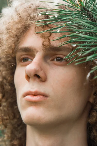 Retrato de um jovem de cabelos encaracolados em um parque de verão na rua. conceito de estudante e jovem viajante — Fotografia de Stock