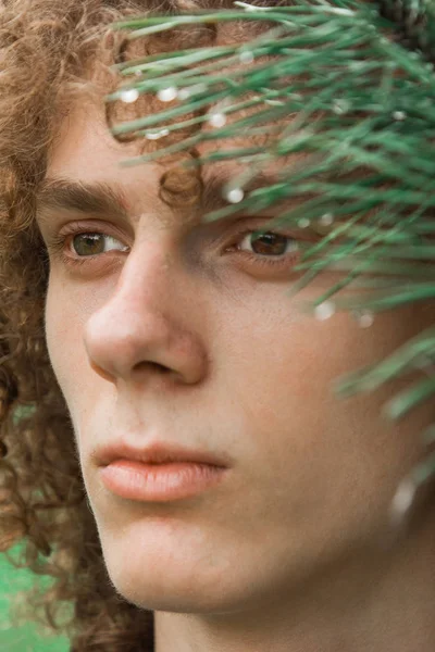 Retrato de um jovem de cabelos encaracolados em um parque de verão na rua. conceito de estudante e jovem viajante — Fotografia de Stock