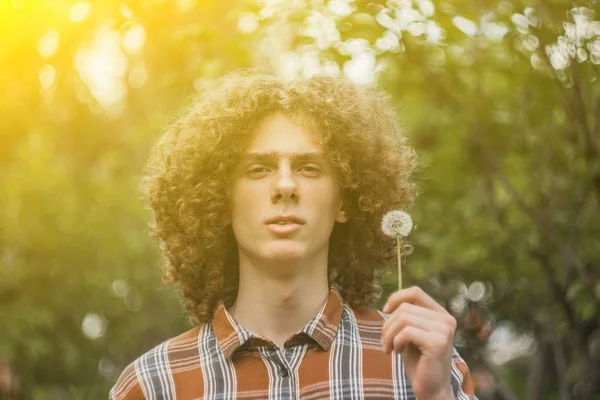 Портрет молодого кудрявого парня в летнем парке на улице. студенческая и молодежная концепция — стоковое фото