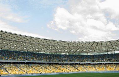 futbol stadyumu içinde görünümü. futbol sahası, boş tribünler, taraftar kalabalığı, gökyüzüne karşı bir çatı