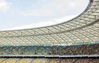 futbol stadyumu içinde görünümü. futbol sahası, boş tribünler, taraftar kalabalığı, gökyüzüne karşı bir çatı
