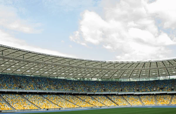 Fotbalový stadion. Fotbalové hřiště, prázdné stánky, dav fanoušků, střecha proti obloze — Stock fotografie