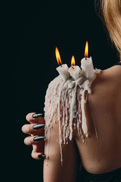 Una chica con el pelo largo en la imagen de una bruja está tratando de prenderse fuego. rituales con velas para hechizo de amor y daño. expulsión de un mal espíritu del cuerpo — Foto de Stock