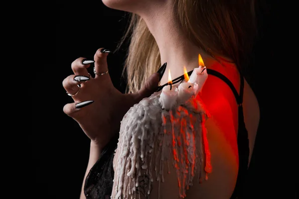 Ein Mädchen mit langen Haaren im Bild einer Hexe versucht, sich selbst in Brand zu setzen. Rituale mit Kerzen für Liebeszauber und Beschädigung. Vertreibung eines bösen Geistes aus dem Körper — Stockfoto
