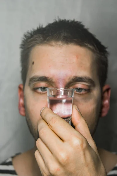 A man suffering from alcoholism drink vodka at home alone, action against alcohol. — Stock Photo, Image