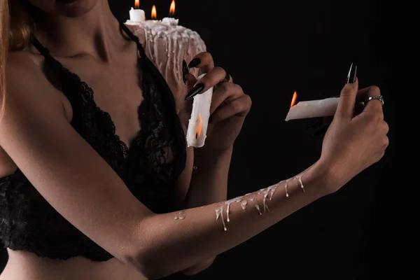 Una chica con el pelo largo en la imagen de una bruja está tratando de prenderse fuego. rituales con velas para hechizo de amor y daño. expulsión de un mal espíritu del cuerpo — Foto de Stock