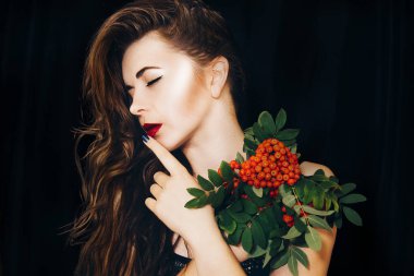 Uzun sarı saçlı, kırmızı böğürtlenli, çıplak omuzlu seksi kız. Siyah bir arkaplanda