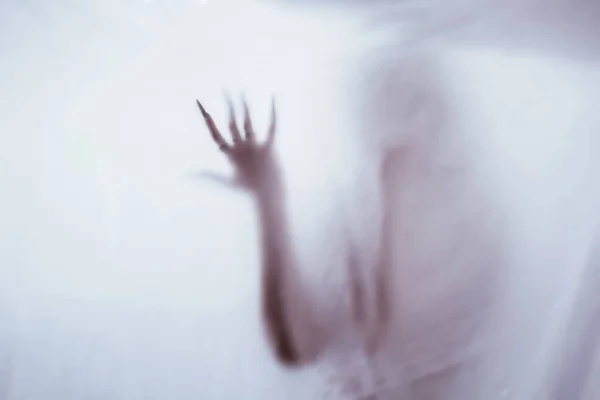 Silhouette of a female sexual figure behind foggy glass. concept of the spirit of poltergeist from the other world. frightening hands of death through the fabric. — ストック写真