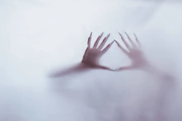 Silhouette of a female sexual figure behind foggy glass. concept of the spirit of poltergeist from the other world. frightening hands of death through the fabric. — Stock Photo, Image