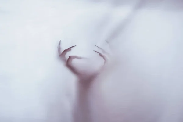 Силует жіночої сексуальної фігури за туманним склом. концепція духу метеорита з іншого світу. страшні руки смерті через тканину . — стокове фото
