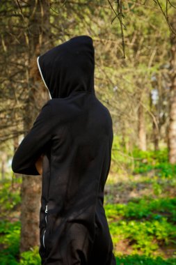 Eşofmanlı yakışıklı, genç adam parkta doğayla iç içe spor yapıyor. Sağlıklı yaşam tarzı