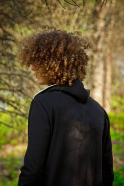 Eşofmanlı yakışıklı, genç adam parkta doğayla iç içe spor yapıyor. Sağlıklı yaşam tarzı