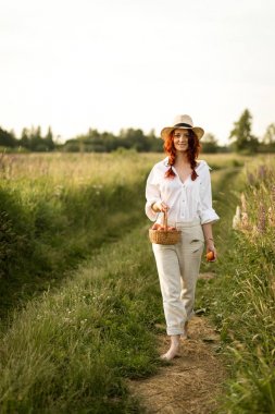 Mutlu gülümseyen kız şeftali bir sepet ile yolda yürürken