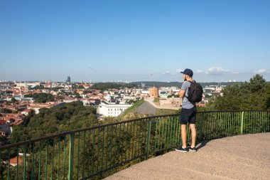 Kuzey Avrupa 'da siyah kameralı bir sırt çantasıyla dolaşan beyaz bir genç.