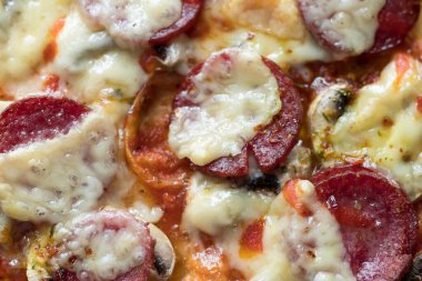 Mozzarella peynirli salamlı pizza, beyaz mantar ve sriracha ahşap bir kesim tahtasına konur.