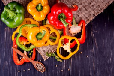 Ahşap arka planda üç tatlı biber, sebze salatası pişirme.