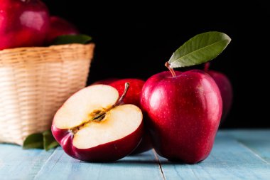 Masada yaprakları olan kırmızı elmalar.