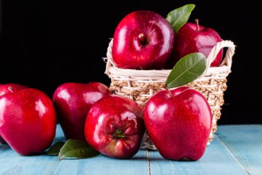 Masada yaprakları olan kırmızı elmalar.
