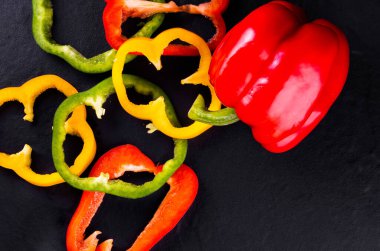 Ahşap arka planda üç tatlı biber, sebze salatası pişirme.
