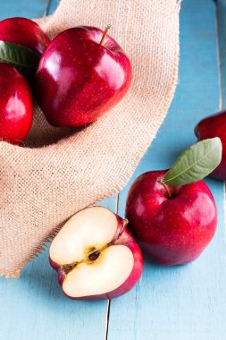 Masada yaprakları olan kırmızı elmalar.