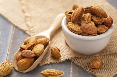 Siyah bir kâsede badem, koyu, ahşap arka plana karşı.