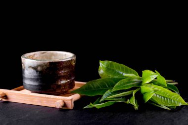 Yeşil çayın üst görüntüsü ahşap yüzeydeki bir kasede eşleşiyor.