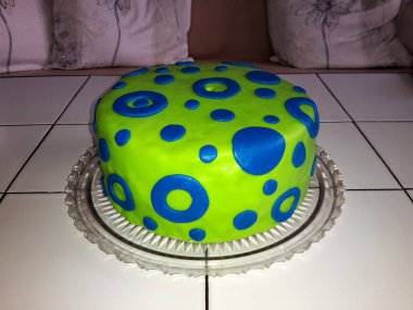 Doğum günü pastası jöleli, yeşil ve mavi süslemeli, cam tepsiye yerleştirilmiş, resim