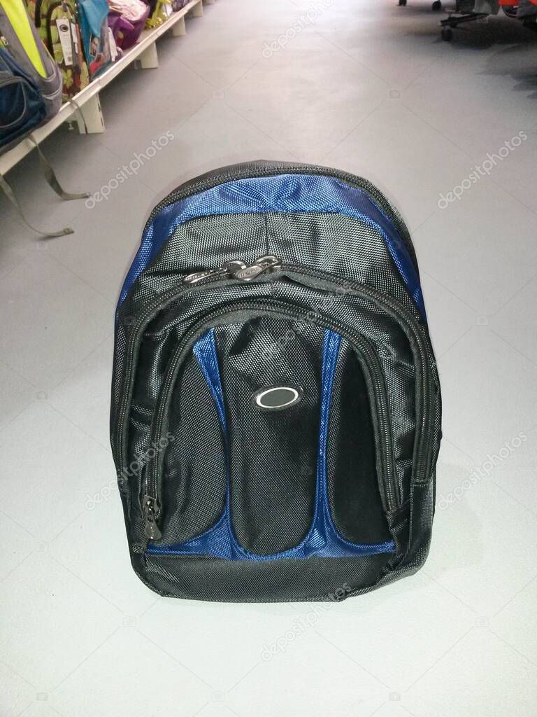 Backpack black-blue on the ground in backpacks and clothes store, image