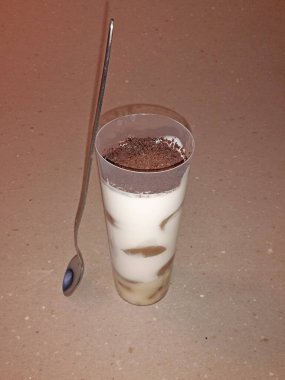 Crucible puding ve sünger bisküvileri ile dolu, üzeri rendelenmiş çikolata, kenarına yaslanmış uzun kaşık, görüntü