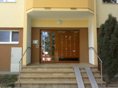 Posta kutuları, zilleri ve bebek arabası rampası olan bir apartman bloğuna giriş, görüntü