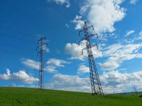 Pylons Aço Alta Tensão Uma Colina Gramada Dia Ensolarado Fundo Imagens Royalty-Free