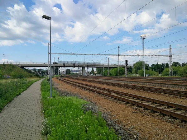 Railway track running under a bridge and passing in the distance, image