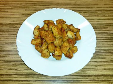 Beyaz bir porselen tabakta kavrulmuş et parçaları.