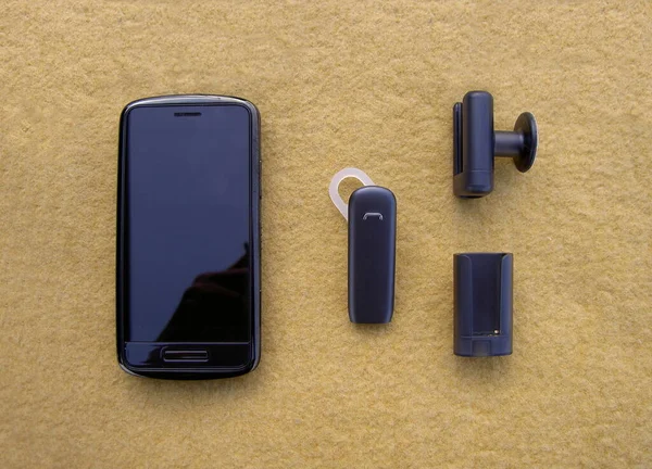 Smartphone black, bluetooth handsfree headset and holders, image