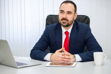 Mavi takım elbise ve kırmızı kravat işadamı dikkatle onun muhatap ofiste için dinler.