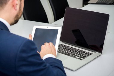  işadamı onun iş ofiste planchette hakkında yararlı bilgi için arıyor. Eller Close-up. dizüstü ve tablet.