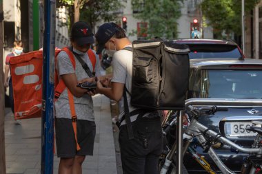 Madrid, İspanya - 19 Mayıs 2020: Ev dağıtım şirketi, fasttiapp 'tan teslimatçılar Madrid sokaklarında çalışıyor, yiyecek ve personel dağıtıyorlar.