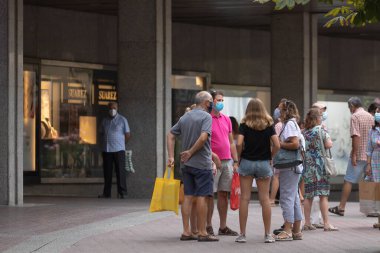 Zaragoza, İspanya - 18 Ağustos 2020: Zaragoza 'nın merkez bölgesinde meydana gelen koronavirüs salgını nedeniyle yüz maskeleriyle konuşan bir grup insan.