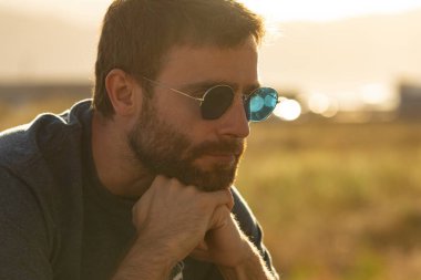 Gözlük takan, kendine konsantre olan genç bir adam, sakin bir şekilde meditasyon yaparken, İspanya 'nın kuzeyinde bir gezinti güvertesinde güneşin tadını çıkarıyor..