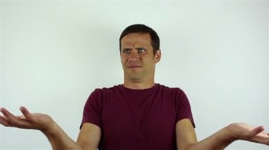 Yakışıklı bir genç adam karmaşa içinde Omuzlarını silkiyor.