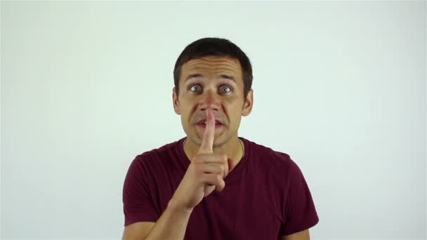 ハンサムな若い男が沈黙を求めて彼の口に指をもたらします. — ストック動画