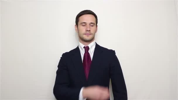 Joven hombre de negocios guapo limpia y ajusta su traje, sonriendo mirando a la cámara — Vídeo de stock