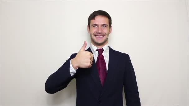 Young handsome businessman smiling and showing thumb up, one and two hands. — Stock Video