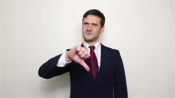 Jovem empresário bonito mostra polegar para baixo, expressando seu desagrado. — Vídeo de Stock
