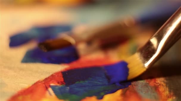 The artist dips his brush in blue paint. . — Stock Video