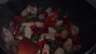 Şef wok tavada sebzeli tavuk karışımları.