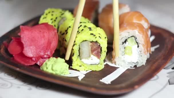 Szef kuchni miejsca rolek sushi na płycie przed podaniem ich do klientów. — Wideo stockowe