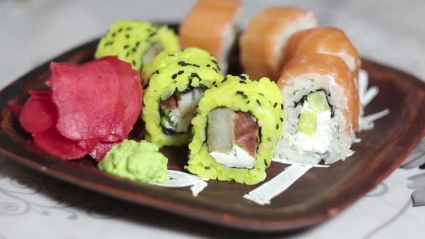 Hand mit Essstäbchen holt Sushi vom Teller. — Stockvideo